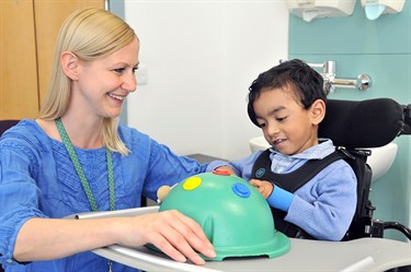 Photograph of an occupational therapist helping a child play 